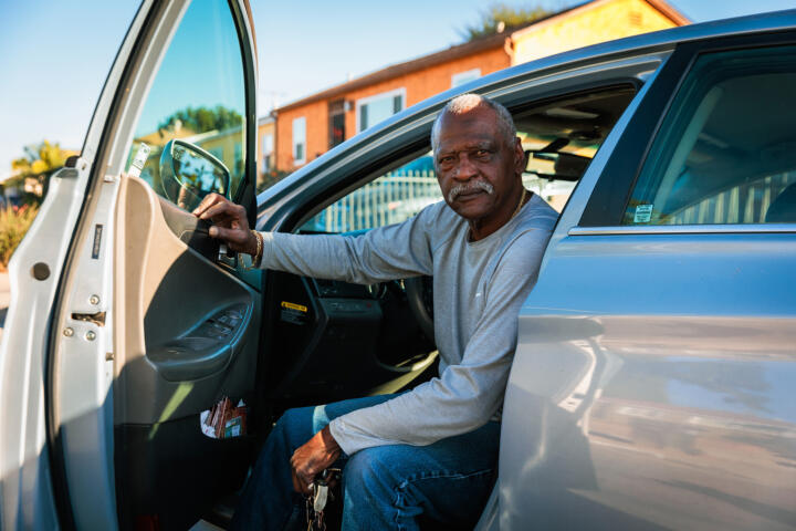 Photograph of Rodney sitting in his car with the door open