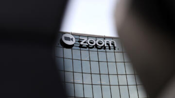 Photograph of the exterior of Zoom headquarters on February 07, 2023 in San Jose, California. The right and left sides of the photograph are obscured by two dark shadows that aren't in focus.