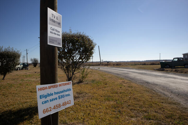 Photograph of a sign attached to a telephone pole that says eligible households can save $30 a month on high-speed internet